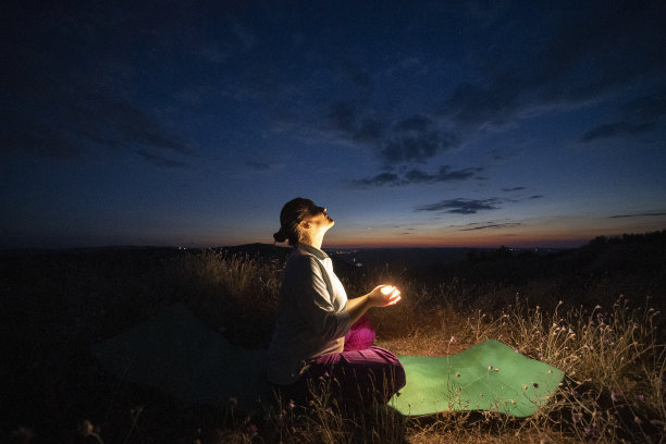 放松，回归自然。晚上做瑜伽。随心。一位快乐的年轻女游客在大自然中做放松练习的照片。图片下载