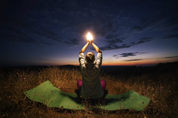 放松，回归自然。晚上瑜伽。随心。一个快乐的年轻女游客在大自然中做放松练习的WS。图片下载