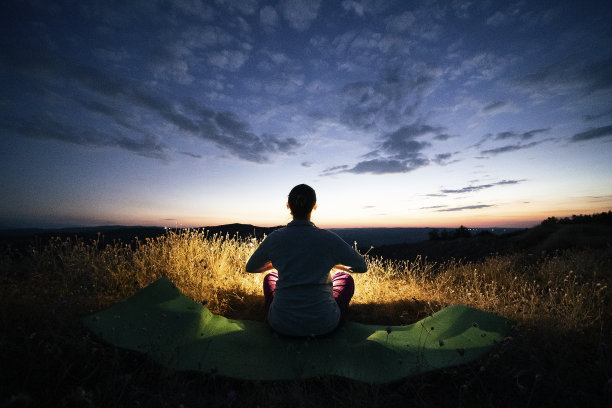 放松，回归自然。晚上瑜伽。随心。一个快乐的年轻女游客在大自然中做放松练习的WS。图片下载