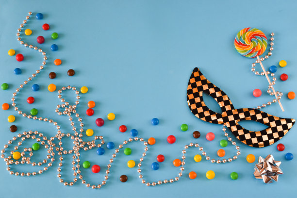 五彩缤纷的狂欢节背景有糖果、珠子和面具图片下载