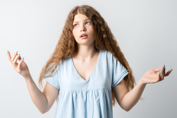 困惑的卷发美女，手势困惑，白色背景照片图片下载