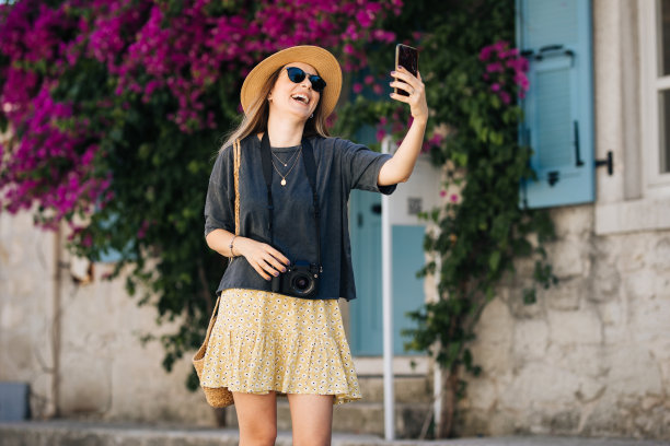 迷人的年轻女子站在城市里自拍图片下载