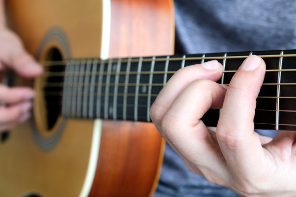 一个年轻人在夏天弹奏尤克里里弦乐器图片下载