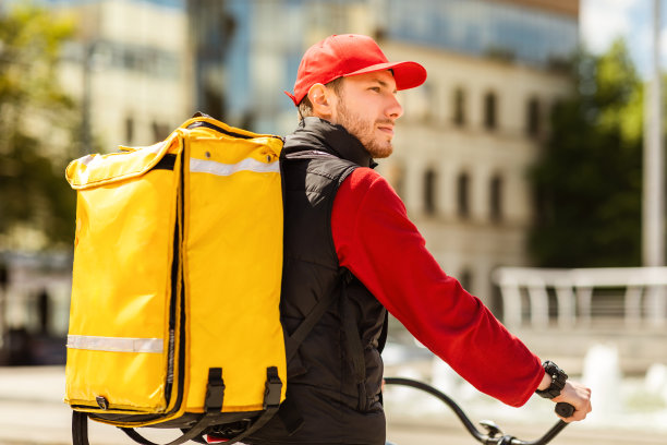 黄色背包的快递员骑自行车在外送食物图片下载