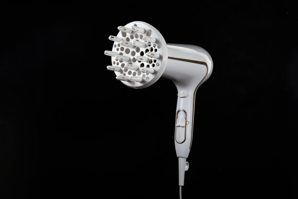 专业时尚的电吹风孤立在一个黑色的背景。带护发工具的白色离子电吹风。现代的吹风机。图片下载
