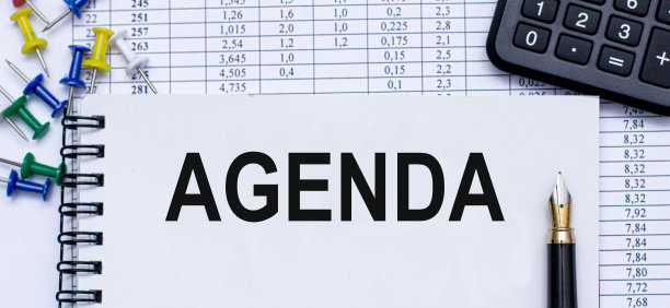 经营理念。议程是写在一个笔记本上，放在一个白色的桌子上，与一支笔，彩色回形针和一个计算器。图片下载