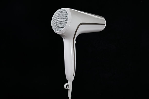 专业时尚的电吹风孤立在一个黑色的背景。带护发工具的白色离子电吹风。现代的吹风机。图片下载