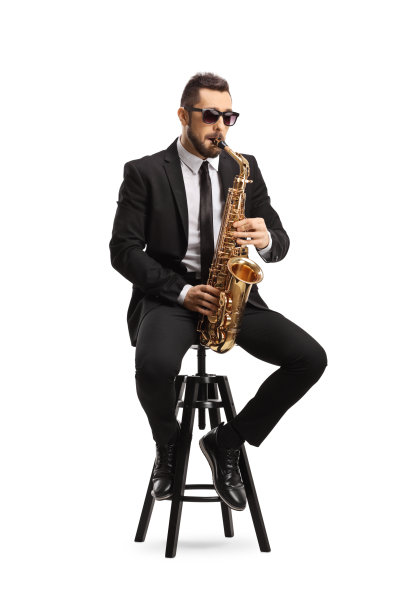 一个穿着黑色西装的英俊男子坐在椅子上吹着萨克斯管图片下载
