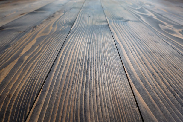 从木地板的角度看。松木板上覆盖着黑色透明的油。树纹理是可见的。背景。图片下载