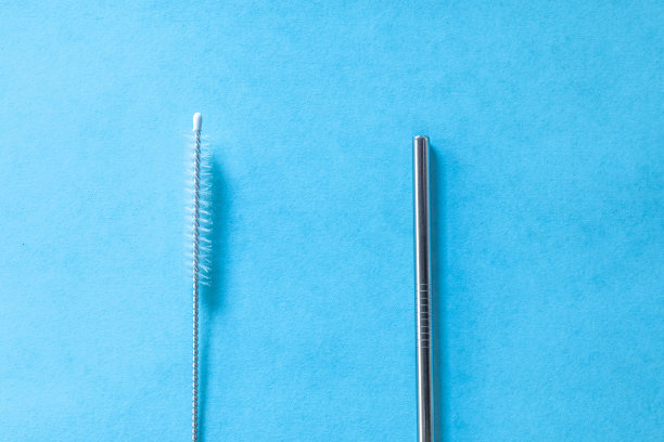 可重复使用的不锈钢吸管和清洁刷，蓝色背景，生态友好的生活方式，拷贝空间，俯视图，平面布局图片下载
