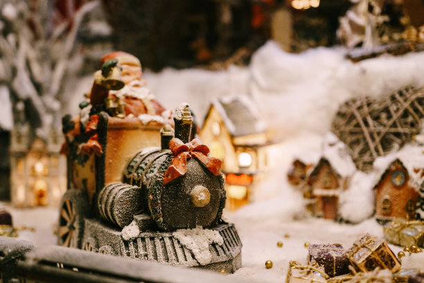 圣诞小雕像的火车与一个红色的蝴蝶结在一个橱窗与人造雪。图片下载