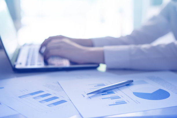 特写的财务文件与笔和商人在笔记本电脑上工作图片下载