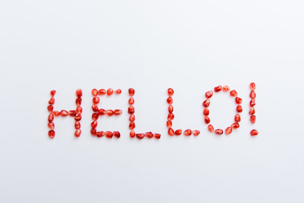 白色背景的石榴籽上的“你好”字图片下载