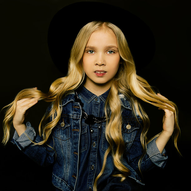 一个美丽的金发女孩的照片与长头发在黑色的背景在牛仔衬衫直发她别致的白色绺。美发沙龙的时尚照片。皮肤纯净，自然美图片下载