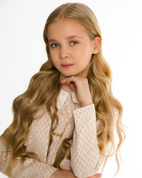 照片上美丽的金发女孩，长长的卷发。时尚时尚的经典服饰。看镜头。白色背景。孤立。女学生8-10岁。完美的学校看看。荣誉学生图片下载