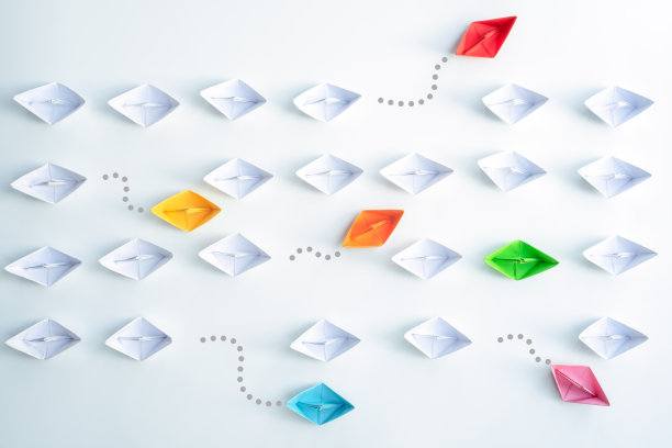 一组纸船在一个方向和一组个人指向不同的方向。业务为创新解决方案的概念。图片下载