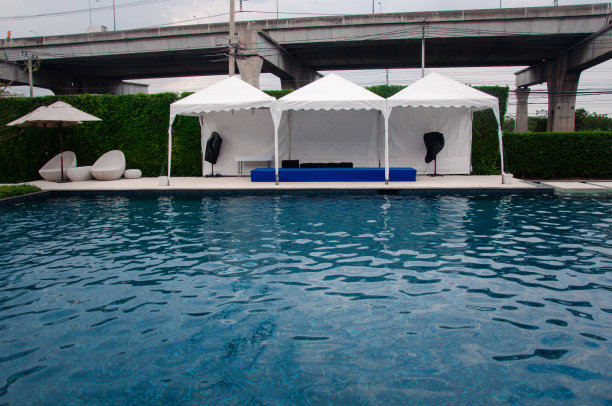 游泳池附近设有舞台和扬声器帐篷，为户外活动做准备。户外派对概念图片下载