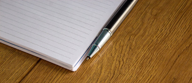 笔记本和钢笔放在木桌上。商业教育理念。图片下载