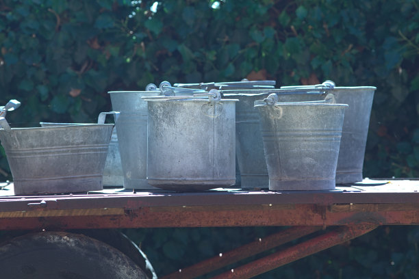 在院子的空地上，一辆手推车上的钢桶图片下载