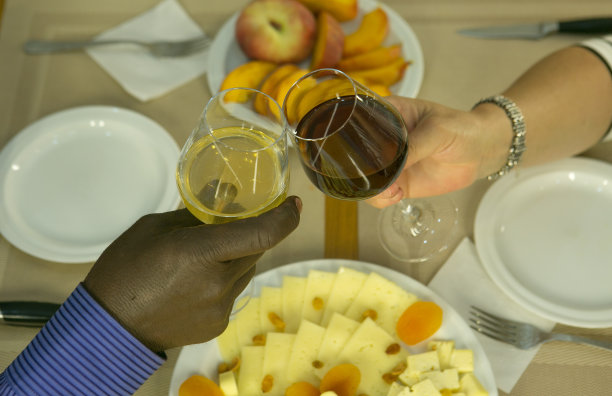抗议活动。在咖啡馆见面。非裔美国妇女和白人妇女的手拿着白葡萄酒和红葡萄酒。图片下载
