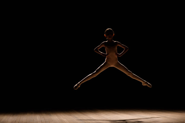 年轻兴奋的女孩在演播室或舞台上跳跃。图片下载