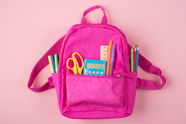 回到学校的概念。上方上方的照片，粉红色的背包和彩色文具孤立在粉红色的背景图片下载