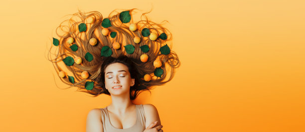 肖像美丽的女孩躺在背景与杏子长头发，概念女性自然美护理，年轻女子的脸俯视图图片下载