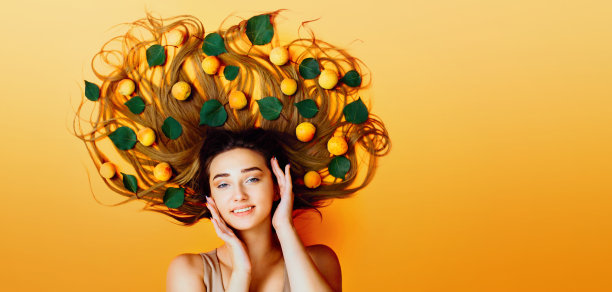 一个美丽的女孩的肖像躺在背景与杏子长头发，概念女性自然美护理，年轻女子的脸俯视图图片下载