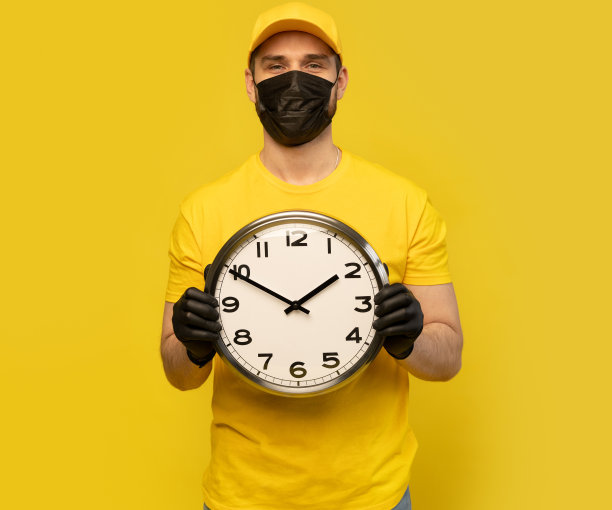 穿黄色工作服的送货员拿着钟。服务的概念。冠状病毒2019 - ncov概念图片下载