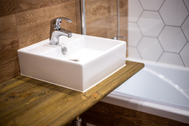 浴室设计。木纹墙板。架子上有一个带搅拌器的方形水槽。图片下载