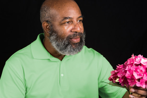 友好的非洲裔美国人与彩色绣球花黑色背景。爱，母亲节或情人节的概念图片下载