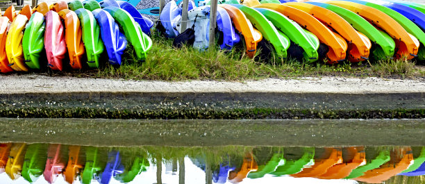 几十艘五彩斑斓的单人出租船堆放在船舷上排成一排，在水面上完全反射出来图片下载