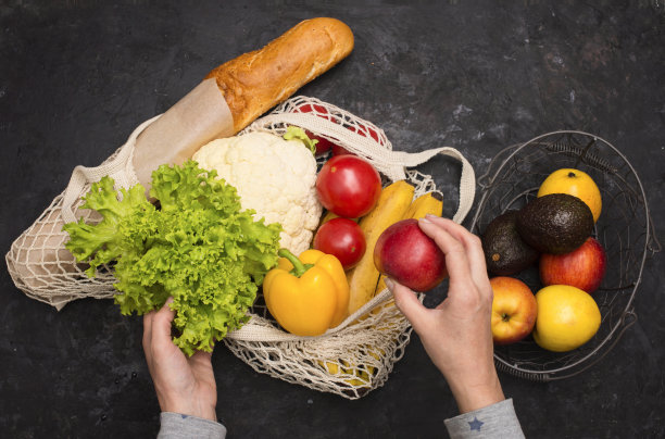 环保网袋水果和蔬菜在黑色的背景。没有塑料。零废物和无塑料的概念。女人手拿食品杂货购物环保袋。可持续和环保的生活理念。图片下载