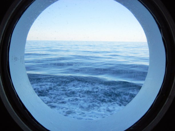 从一艘船的圆形船舱窗户看大海在意大利照片图片下载