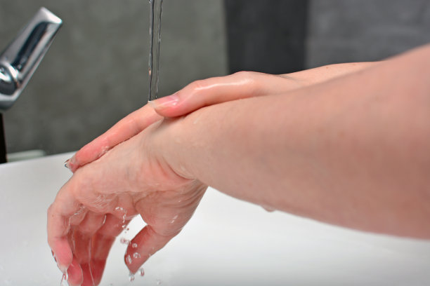 一名年轻女子在疫情期间按照卫生规则洗手图片下载