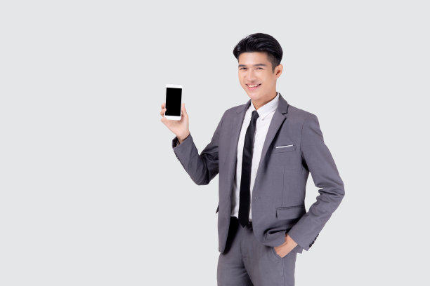 肖像年轻的亚洲商人展示和展示智能手机与空白与成功孤立在白色背景，商人站着和拿着手机，沟通概念。图片下载