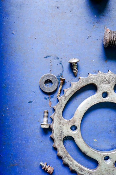 木制桌子上的旧齿轮和旧螺母图片下载