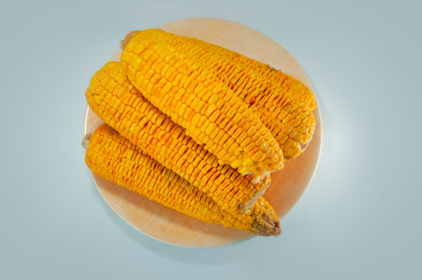 一盘烤有机甜玉米放在白盘上图片下载
