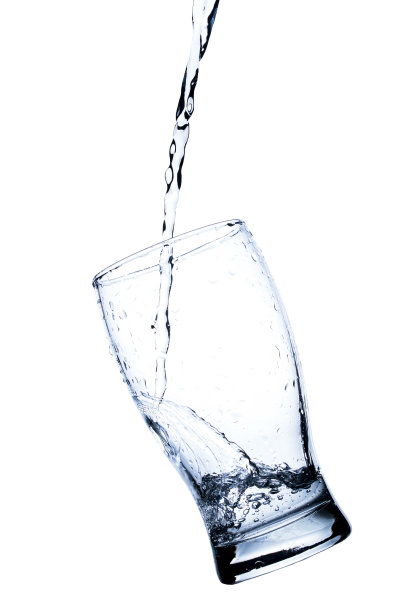 水飞溅在一个透明的玻璃上，孤立在白色的背景上图片下载