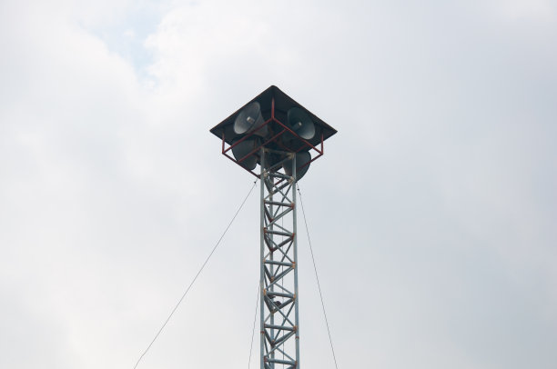 老式的公共扩音器在高塔上播放复古风格的蓝天背景图片下载