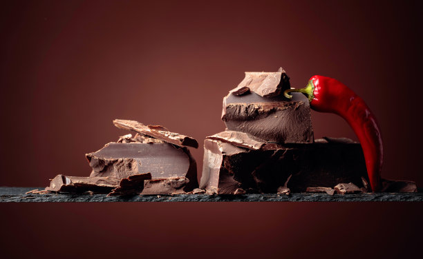 黑巧克力和红辣椒在棕色的背景。图片下载