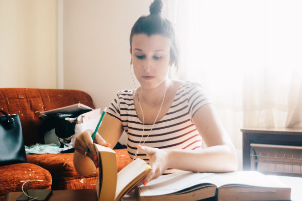 年轻女子读一本书在家里库存照片图片下载