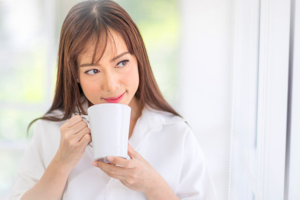 手持咖啡杯的亚洲女性图片下载