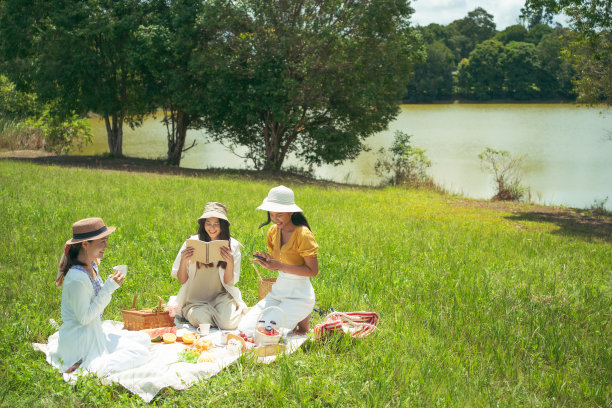 亚洲女性朋友，他们在野餐，在早上吃饭，他们愉快地交谈。图片下载