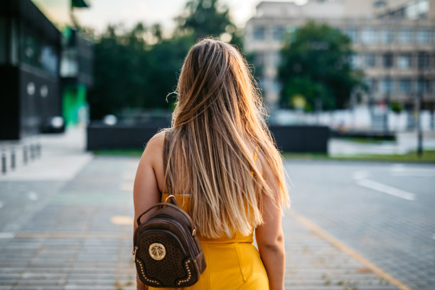 一个背着小背包的金发女人图片下载