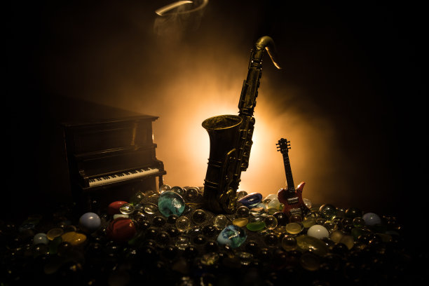 在朦胧的背景上，带有彩色调的金色萨克斯微型。在昏暗的光线下演奏萨克斯乐器。有选择性的重点图片下载