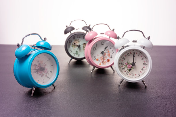 一套漂亮的新闹钟上的黑色皮革彩色彩色的背景。图片下载