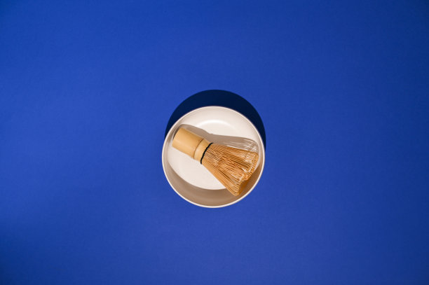 搅茶器配白色陶瓷碗。制作传统日本饮料的原料。健康和替代医学。框架内的强光。副本的空间。以上。高质量的照片。图片下载