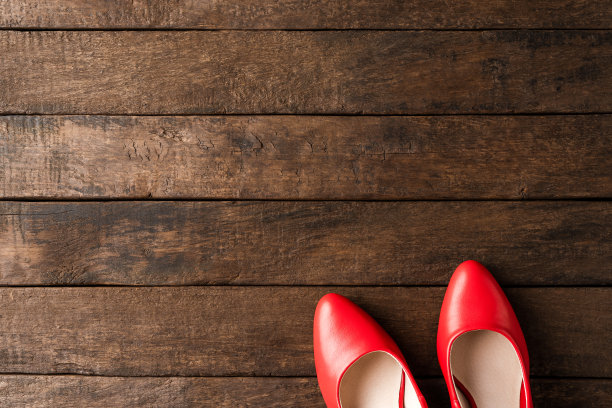Red high heels on wooden background with copyspace. Women’s shoes图片下载