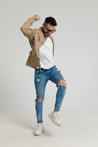 快乐的少年休闲的男人在夹克里举着手臂在空中跳跃图片下载